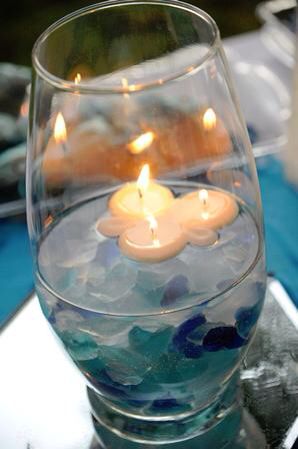 Seaglass centerpiece idea Beach Centerpieces Diy, Seaglass Wedding, Wedding Table Decorations Candles, Glass Wedding Centerpieces, Sea Glass Candles, Nautical Centerpiece, Tree Wedding Centerpieces, Diy Floating Candles, Sea Glass Wedding