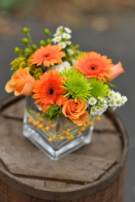 Centerpiece of peach roses, orange gerber daisies, green mums and white asters in silver cube wrapped in peach beaded wire Roses Orange, Tafel Decor, Flower Delivery Service, Gerber Daisies, Arrangement Ideas, Square Vase, Flower Arrangements Diy, Fresh Flowers Arrangements, Vase Arrangements