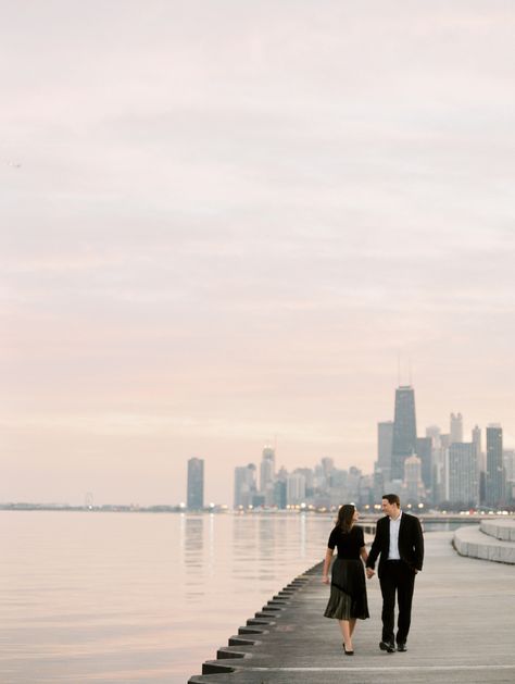 couple walks during sunset on the waterfront with Chicago city skyline in the background by film wedding photographer Mary Dougherty Michigan Proposal Ideas, Chicago Photoshoot, Chicago Engagement Pictures, Chicago City Skyline, City Engagement Pictures, Proposal Inspiration, Chicago Engagement Photos, Engagement Picture Outfits, Spring Engagement Photos