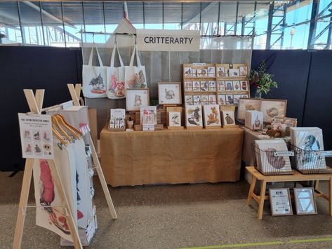 Market stall set up including L shaped table display for art prints, greeting cards and wooden A frame display for tea towels. All products feature pencil artwork of Australian animals by Lenny Pelling. Market Stall Set Up, Ideal Workplace, Craft Market Stall Ideas, Art Festival Booth Display, Festival Booth Display, Market Stall Display Ideas, Art Festival Booth, Art Fair Display, Market Stall Display