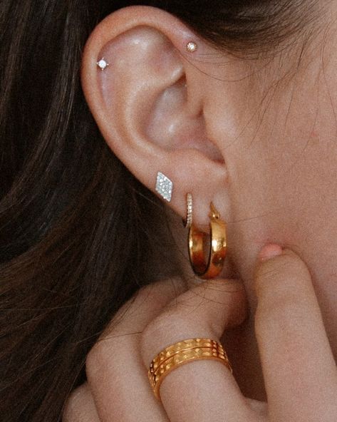 10 Piercings You Should Get Next Ear Piercings Forward Helix Triple, Gold Forward Helix Piercing, Helix And Forward Helix Piercing Chain, Tiny Ear Piercings, Forward Helix Piercing Hoop, Forward Helix Hoop, Curated Ear Piercing, Triple Ear Piercing, Triple Forward Helix Piercing