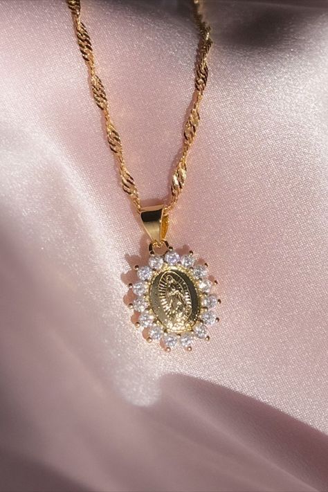 Embrace the grace and elegance of our Virgin Mary Necklace, a symbol of devotion. This exquisite piece features a radiant pendant in 18K gold plating over sterling silver, encircled by a ring of sparkling cubic zirconia stones. Inspired by faith and crafted with meticulous detail, this necklace embodies the perfect blend of spirituality and beauty. Elevate your style and carry the essence of faith with you. Shop now and adorn yourself with this exquisite Virgin Mary pendant! Mary Necklace, Catholic Necklace, Virgin Mary Necklace, Delicate Gold Necklace, Lady Of Guadalupe, Dragon Necklace, Medallion Necklace, Jewelry Lookbook, Dragon Pendant