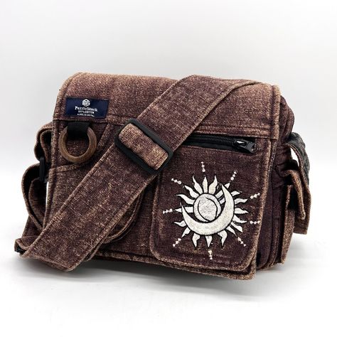 Lukla Brown Stone-Washed Sunmoon Embroidered Messenger Bag This Is A Compact Yet Voluminous Bag. Along With Its Multiple Pockets Used For Storage, It Includes A Large Flap Closure With Velcro. Starting Off With The Two Front Pockets, Open Up The Flap To Find The Main Compartment Following The Large Extra Pocket, And Even A Cute Mini Side Pocket! Make Travel Hands-Free With This Spacious Bag. Not Only Is This Bag Sustainable And Eco-Friendly, But Made Of Heavy Cotton Outside, Lined With Cotton In Messenger Bag Shop, Brown Side Bag, Messager Bags Aesthetic, Messenger Bag With Pins, Thrift Accessories, Traveler Clothes, Sewed Bags, Messenger Bag Aesthetic, Goblincore Bag