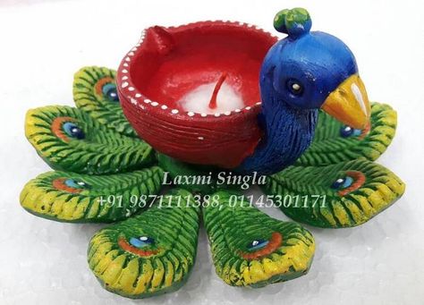 Peacock design with Diya made up by Terracotta Clay Art enhanced with attractive colours. Diya Decoration Ideas With Clay, Diwali Clay Art, Peacock Diya Decoration, Diwali Clay Craft, Clay Diya Decoration Ideas Creative, Clay Diyas For Diwali, Clay Peacock, Clay Diya, Diya Designs