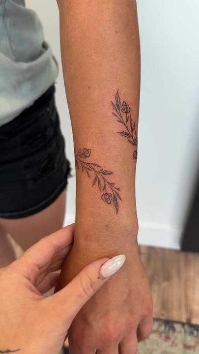 Flower Around Wrist Tattoo, Writing Tattoos With Flowers, Birth Flower Wrist Wrap Tattoo, Western Wrist Tattoos, Flower Wrist Wrap Tattoo, Vine Tattoo On Arm, Flower Arm Wrap Tattoo, Flower Wrap Tattoo, Wrap Around Flower Tattoo Arm