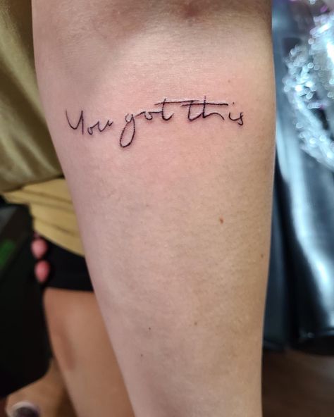 Tattoo in black ink saying “you got this” on upper arm in a script like font Written Arm Tattoos For Women, I Got This Tattoo, You Got This Tattoo Fonts, Motivational Arm Tattoos, Writing On Arms Tattoo, You Got This Tattoo Ideas, You Got This Tattoo, Love You More Arm Tattoo, Tattoo You