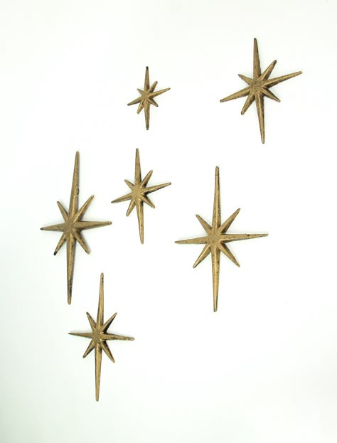 This sextet of 8 pointed compass stars adds a wonderful Mid-Century modern touch to your indoor or outdoor decor. Crafted of cast iron, the stars feature an antiqued enamel finish to give them a great aged look. Each set has one XL star measuring 8.75 inch long, 0.25 inch wide, 12 inch high; two large stars measuring 7 inch long, 0.25 inch wide, 8.75 inch high; two medium stars measuring 5.75 inch long, 0.25 inch wide, 6.75 inch high, and one small star measuring 4.25 inch long, 0.25 inch wide, Star Decorations, Wall Decor Set, Gold Walls, Dream House Decor, Room Themes, House Inspo, New Room, Future House, Metallic Gold