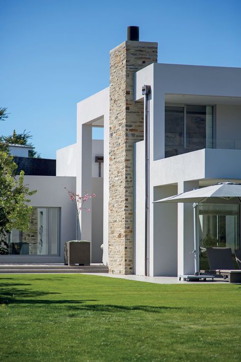 A nod to local materials, architect Richard Shackleton has used schist to clad the chimney. Concrete Chimney Exterior, Exterior Chimney Ideas, Chimney Exterior, Outdoor Bars, Garage Guest House, Modernist House, New Zealand Houses, House Design Exterior, Home Exterior Makeover