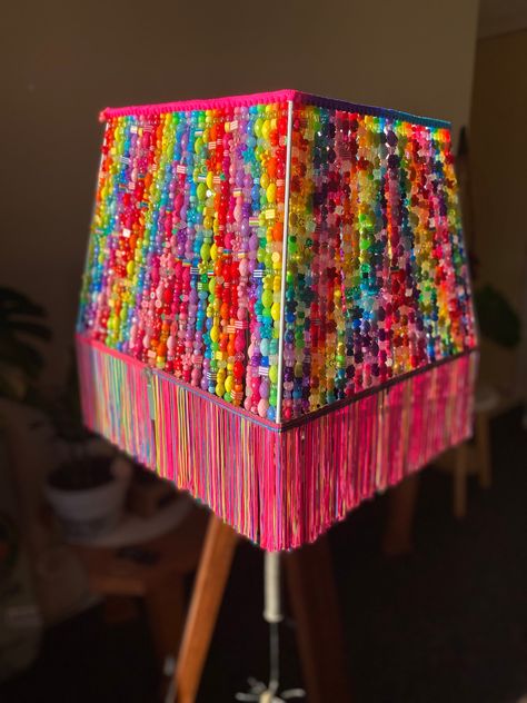 Large rainbow hand beaded lampshade with an assortment of beads from glow in the dark beads to add some extra magic once the lights turn off, pony beads, shapes such as hearts, flowers, stars, oval and square beads,  With a retro neon tassel base and a neon rainbow Pom Pom trim for the top, Hippie Crafts Ceiling Lights, Diy Bead Lamp Shade, Lamp Shades With Beads, Kidcore Room Ideas, Lampshade Crafts, Lampshade With Beads, Beaded Lamp Base, Beads Lampshade, Beaded Shade Lamp