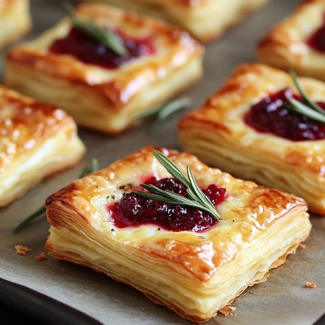 Impress your guests with these delicious Cranberry Brie Bites! 🧀🍇 A delightful treat perfect for any gathering!" Cranberry Brie Bites Ingredients: Puff pastry sheets (1, thawed) Brie cheese (8 oz, cut into cubes) Cranberry sauce (½ cup) Fresh rosemary (for garnish) Egg wash (1 egg, beaten) Instructions: Preheat oven to 375°F (190°C). Roll out puff pastry and cut into squares. Place a cube of brie and a teaspoon of cranberry sauce on each square. Fold pastry over the filling and pinch to s... Cranberry Goat Cheese Puff Pastry, Cranberry Sauce Brie Puff Pastry, Cranberry And Brie Bites, Cranberry Brie Bites Puff Pastries, Thanksgiving Puff Pastry, Cranberry Brie Pastry, Cranberry Pastry, Brie Bites Puff Pastry, Cranberry Brie Puff Pastry