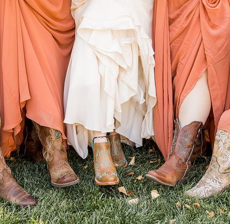 Focus on assorted brown leather boots being worn by bride and her bridesmaids Cowgirl Boots Bridesmaids, Wedding Cowgirl Boots Bridesmaids, Rustic Brown Boots For Western-themed Events, Bridesmaids Cowboy Boots, Bridesmaids In Boots, Cowboy Boot Wedding Pictures, Westeen Boots And Wwdding Gowns, Ranch Style Weddings, Western Engagement Photos