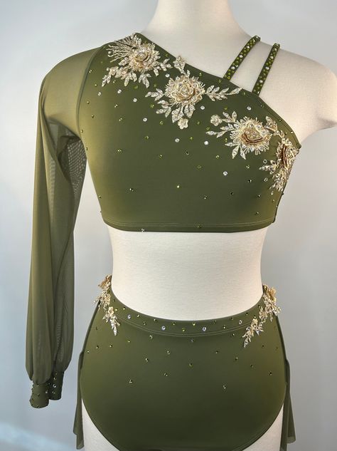 A Glamourous Green- Simply Barefoot- 2 Piece- Semi-Custom Costume perfect for a solo dance at a competition!  * Simply Barefoot- One Shoulder Crop Top with Bishop Sleeve and High Waist Dance Brief w/ 2 layer back skirt. * 6 Hand sewn gold colored appliques featuring 3D gold flowers. * 684 Preciosa Maxima crystals in colors: Olivine & Light Gold Quartz Sizing:   Please see brand specific size chart in photos, as sizing varies depending on brand.  This information is shown as a guide and not a guarantee. * All sales final. Dance Competition Outfits, Green Dance Costume, Surprise Dance Outfits, Waist Dance, Dance Wear Outfits, Solo Dance Costumes, Pretty Dance Costumes, Solo Dance, Competition Outfit