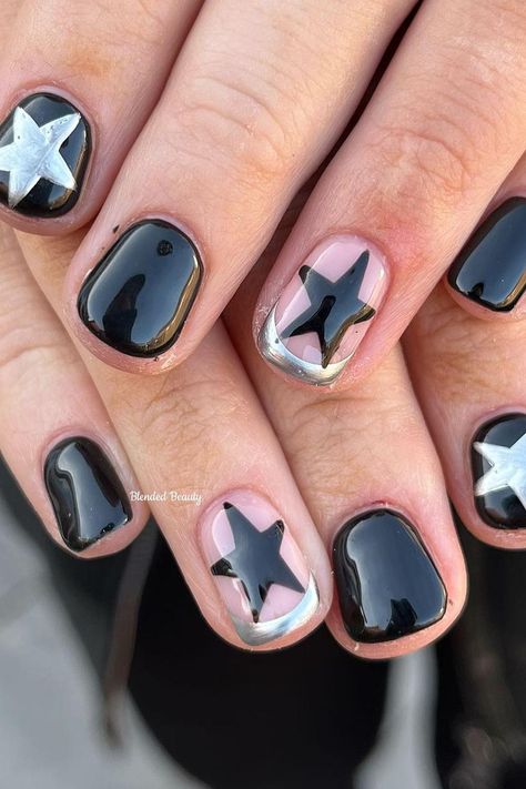 These short, rounded nails present a chic and playful contrast. A glossy black base gives a classic, sophisticated look, while pink nails with bold black stars add a pop of whimsy. Metallic silver embellishments outline some of the designs, providing a striking frame that ties the look together seamlessly. It's a modern twist on a starry night theme, full of style and fun! ✨  // Photo Credit: Instagram @blendedbeauty.mb Star Short Nail Designs, Silver Nails With Black Stars, Metallic And Black Nails, Cute Manicures For Short Nails, Pop Star Nails, Nail Inspo Black And Silver, Black Chrome Nails Short, Black Nails With Chrome Design, Short Nail Star Designs