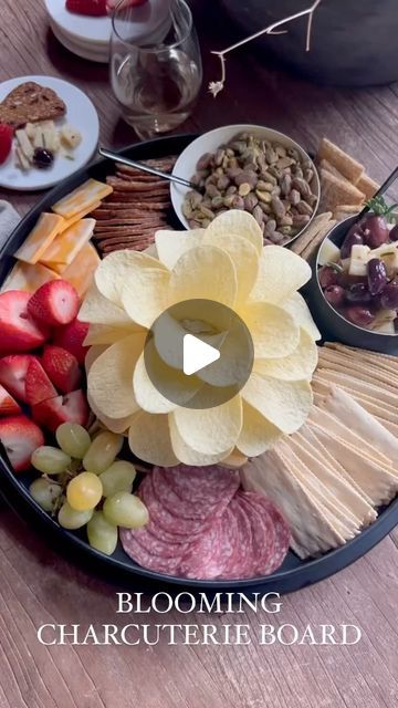 Melaine Thompson on Instagram: "BLOOMING CHARCUTERIE BOARD- Save this post & tag a friend who would like this! This charcuterie board was so fun to put together and the star of the show is the blooming cheese dip in the center. Here’s how to put it together- 1-place a round of Boursin cheese on a plate or tiered tray. 2-staring at the base press in 7 Pringle’s chips all the way around. 3-repeat the layers all the way to the top, finishing with 2 chips to make the center bud. 4-add other meats, cheeses, fruit and nuts around the flower and enjoy! #charcuterie" How To Arrange A Charcuterie Board Video, Single Charcuterie Board, Pringle Flower Dip, Chip Charcuterie Board Ideas, Pringles Flower Dip, Flower Theme Charcuterie Board, Flower Charcuterie Board Ideas, Charcuterie Basket Ideas, Chip And Dip Charcuterie Board