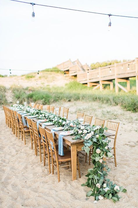 Outdoor wedding vow renewal beach reception with long wooden farm table with draping eucalyptus centerpiece garland #beachwedding #weddingreception #eucalyptus #outerbanks #obx #weddingflowers #florals Eucalyptus Beach Wedding, Beach Reception For Wedding, Beach Vowel Renewal, Beach Vow Renewal Ideas, Beach Reception Ideas, Wooden Farm Table, Centerpiece Garland, Beach Vow Renewal, Eucalyptus Centerpiece