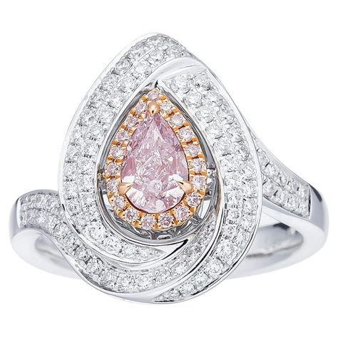 This stunning ring, known as the "Ethereal Light Pink Diamond Ring," exemplifies the pinnacle of luxury and exquisite craftsmanship. The centerpiece of this remarkable piece is a 0.50-carat pear-shaped diamond, GIA-certified (GIA NO: 2225633754) with a light pink color grade that adds a touch of romantic elegance. Surrounding the central diamond are meticulously arranged round white diamonds weighing a total of 0.49 carats (93 pieces), and smaller fancy pink diamonds totaling 0.065 carats (19 pi Ethereal Light, Pink Diamond Ring, Contemporary Engagement Rings, Solitaire Diamond Ring, Solitaire Rings, Natural Diamond Ring, Natural Diamond Engagement Ring, Fancy Diamonds, Solitaire Diamond