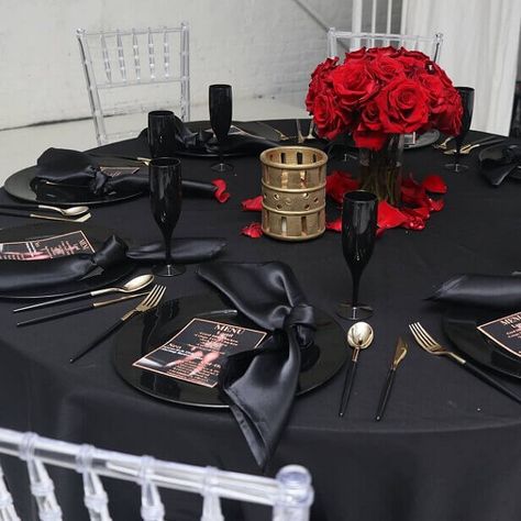 Set up a stunning black table setting and exhibit style and sophistication into your party ambiance. Dress the party table with a black polyester tablecloth and create an upscale place setting by arranging black chargers, black napkins, black handle gold cutlery, & black flutes. Spread a lovely floral charm by displaying a striking red rose flower centerpiece in the middle and scatter red rose petals all over to add a WOW factor to your tablescape. Black Tablecloth Wedding, Black Table Setting, Red Table Settings, Masquerade Party Decorations, Gold Table Setting, Red Centerpieces, Black Charger, Black Napkins, Black Tablecloth