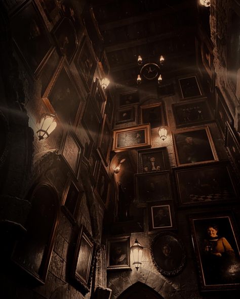 dark room with pictures covering the walls, pretty lanterns hanging on the walls. Hogwarts stairwell with moving portrait paintings Dark Academia Aesthetic Gray, Magic Dark Academia, Fantasy Dark Academia Aesthetic, Haunted Boarding School Aesthetic, School Aethestic Dark, Harry Potter Aesthetic Dark Academia, Dark Academia 1800s Aesthetic, Dark Academia Halloween Aesthetic, Magical Dark Academia