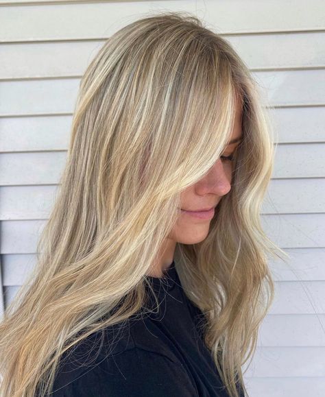 A girl looking down wearing a black t-shirt showing off her new salon hair. She has loosely curled beach waves and bright blonde highlights on dark blonde hair. The highlights are heavier at the front and there is a bright blonde money piece. Neutral Tone Blonde Highlights, Blonde With Foils, Natural Beachy Blonde, Blond Balayage Medium Length, Full Blond Highlights, Blond Partial Highlights, Scandi Blonde Highlights, Balayage With Babylights Blonde, Blonde Hilights With Money Piece