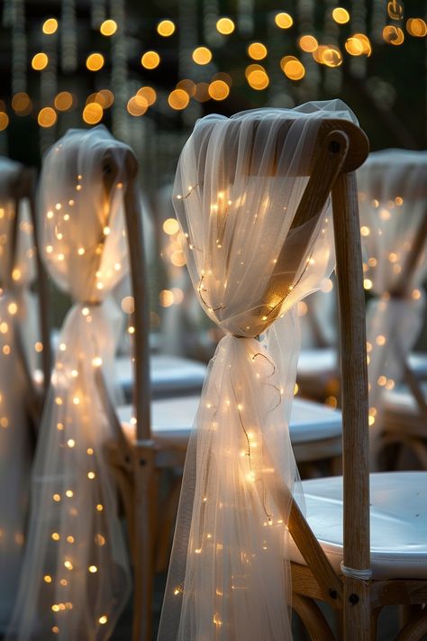 Transform your wedding into a fairytale with these stunning chair decorations. Tulle sashes and fairy lights add an ethereal touch to your reception. ✨🎀💡 Easy DIY setup for a night of wonder. #WeddingInspiration #FairyLights #DIYWedding #WeddingDecor #TulleDecorations #MagicalEvening #BridalStyle #WeddingChairDecor Let the romance sparkle! Fairytale Wedding Centerpieces Diy, Diy Wedding Lights, Woodsy Wedding Reception Decor, Fairy Light Decor Wedding, Wedding Chair Tulle, Fairy Wedding Indoor, Rustic Lights Wedding, Romantic Fairytale Aesthetic, Night Wedding Ceremony Indoor