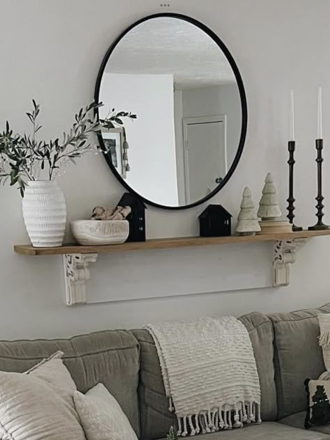 Wall Decor With Round Mirror Living Room, Round Shelf Above Couch, Black Circle Mirror Living Room, Large Mirror In Living Room Behind Couch, Circle Mirror With Shelf Underneath, Living Room Circle Mirror, Mirror And Shelf Above Couch, Shelf Mirror Living Room, Mirror Wall Decor Living Room Floating Shelves