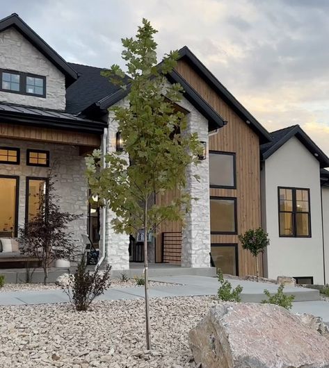 Modern Farmhouse Garage Exterior, Gray Black White House Exterior, House Vinyl Siding Ideas Exterior, Black White House Exterior, Black House With Light Stone, Home Exterior Black Windows, Dark Wood And Stone House Exterior, Timeless Exterior House Colors, Pnw Modern Home Exterior