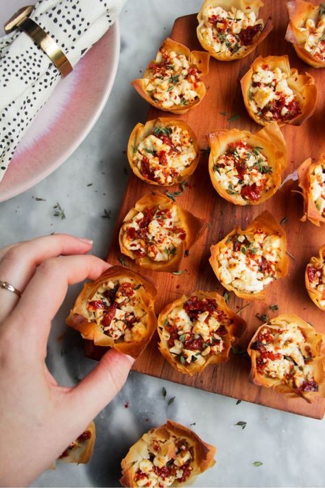 Quick, easy, festive colours, deep flavour...there's a lot to love about these sundried tomato feta filo cups. Pop filo in a mini muffin tin, then top with a speedy mix of feta, sundried tomatoes, thyme and feta and bake until golden. A simple, crowd-pleasing appetizer to impress. Feta Puff Pastry Appetizers, Feta Cheese Appetizer Recipes, Sun Dried Tomato Appetizer Recipes, Filo Pastry Appetizers, Fall Apps For Party, Sundried Tomato Appetizer, Filo Appetizers, Sun Dried Tomato Appetizer, Vegetarian Party Foods