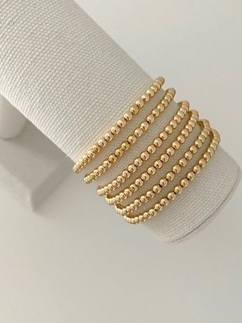 one 14k gold plated stacking bracelet bracelets are made on a durable stretch elastic cord please refer to our sizing guide before purchasing Hold Bracelet Stack, Good Beaded Bracelets, Gold Bracelet Sets, Stackable Gold Bracelets, Beaded Gold Bracelet, Gold Beaded Bracelets Stack, Gold Bead Bracelet Stack, Gold Stacked Bracelets, Bracelet Ideas Gold