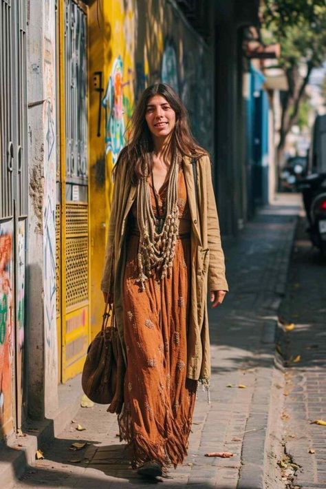 A stylish woman is seen walking confidently on the sidewalk, her brown bag in hand. She effortlessly combines bohemian rhapsody with classic tailoring, as evident from her ensemble. She dons a fashionable brown top, paired with a matching skirt and blazer. The blend of these elements creates a unique and eye-catching look. The woman's fashion-forward sense is highlighted by her choice of clothing, showcasing her individuality and love for style. Wonderfruit Outfit, Matching Skirt And Blazer, Boat Outfits, Hippie Boho Outfits, Modern Bohemian Clothing, Boho Outfits Bohemian, Boho Hippie Fashion, Hippie Chic Outfits, Bohemian Style Bag