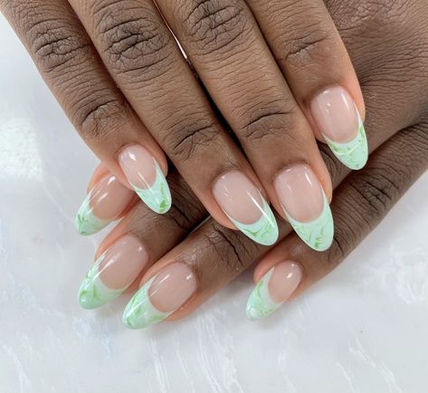 These colored french tip nails are a dream in pastel green. 💚 @kela_stl created the french tips by mixing #HowDoesYourZenGardenGrow, a light green nail polish, with #GelatoOnMyMind, an icy-cool pastel blue. #ImSoooSwamped, a verdant green, and #AlpineSnow, a crisp white, were used for the marbled look. #OPI #OPIObsessed #AskForOPI #Nails #SpringNailArt #FrenchMani #FrenchTips #GreenNails Light Green French Tip Nails, Light Green Nail Polish, Colored French Tip Nails, Green Mani, Colored French Tips, White French Nails, Verdant Green, Short Gel Nails, Green Nail Designs