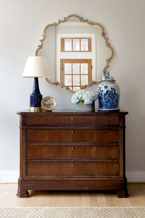 A walnut chest and burnished-brass mirror create a pretty-and-practical vignette.  Interior Design: Andrea Houck | A. Houck Designs Photo: Jenn Verrier  Visit ahouckdesigns.com for more  #ahouckdesigns #handdportfolio #top100designers #interiordesign #design #interiors Brass Mirror Living Room, Mirror Vignette, Southern Traditional Interior Design, Warm Interior Design, Sideboard Styling, Living Space Decor, European Home Decor, Casa Vintage, Arlington Va