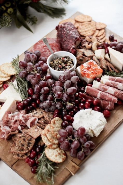 How to Create a Festive & Rustic Holiday Charcuterie Board - This step-by-step guide will help you create the perfect DIY rustic charcuterie board for your next party. Includes ideas on how to balance your board, how to garnish it, and what ingredients work best. This board uses a mixture of soft and hard cheeses, cured meats, jams & jellies, grapes, mixed nuts, crackers, and olive topenade from Trader Joe's. Ideas for garnish include fresh rosemary sprigs. - Rain and Pine Christmas Charcuterie Board Ideas, Holiday Charcuterie Board, Perfect Charcuterie Board, Holiday Charcuterie, Christmas Charcuterie Board, Christmas Pizza, Chocolate Vodka, Holiday Facts, Christmas Charcuterie