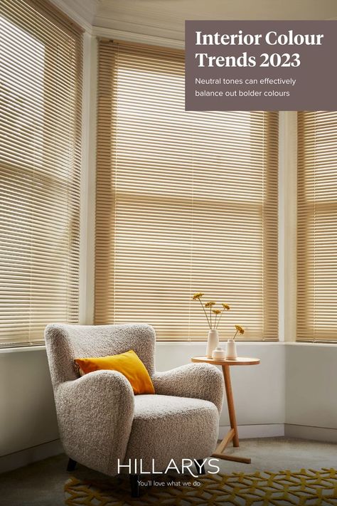 Studio Harvest Venetian blinds at a living room bay window with a boucle armchair and a small wooden coffee table in front. Venetian Blinds Living Room, Blinds Living Room, Living Room Bay Window, 50 Plus, Neutral Colours, Venetian Blinds, Bay Window, Neutral Tones, Neutral Colors