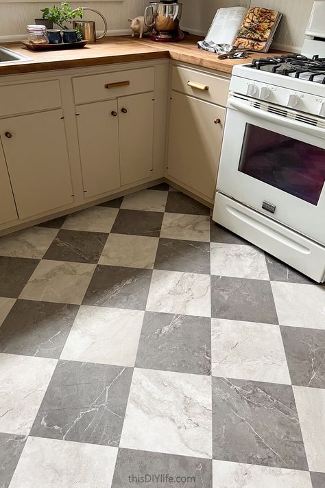 We found the BEST faux marble checkerboard floor tiles - they're budget-friendly, beautiful and the DIY is simple. Plus, our expert tips will make installing these classic dark gray and white checkerboard floors easy. You won't believe they're peel and stick!. The kitchen before and after photos will impress you! White Kitchen Checkered Floor, Kitchen Vinyl Sheet Flooring, Light Grey And White Checkerboard Floor, Checker Board Floors In Kitchen, Checkerboard Vinyl Flooring, Peel And Stick Flooring Kitchen, Checkered Vinyl Flooring, Vintage Checkered Floor, Marble Checkered Floor Kitchen