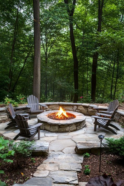 Backyard fire pit surrounded by Adirondack chairs in a forest setting. Fire Pit Ideas In The Woods, Landscape Ideas Fire Pit, Decomposed Granite Fire Pit, Firepits Backyard Ideas Pavers, Fire Pit Brick Pavers, Fire Pit Yard Ideas, Fire Pit Ideas Sloped Backyard, Large Outdoor Firepits, Florida Fire Pit Ideas