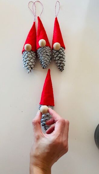 Make these adorable christmas gnomes in minutes using pine cones. If you like these cute gnomes, let me show you how to make them. Step 1 collecting pine conesI selected a variety of pine cones, I tried to pick up the big ones. Step 2 painting the pine conesI used white spray paint to color my pine cones and left them dry. Step 3 making the hat I used red felt fabric for the hat. I cut a small piece of felt that is like a quarter of a circle. Step 4 the hat I gave the felt… Pine Cone Gnomes Diy, Pinecone Gnomes Diy, Pinecone Christmas Crafts, Pine Cone Gnomes, Pinecone Gnomes, Diy Christmas Gnomes, Gnome Christmas Ornaments, Clothes Pin Ornaments, Pinecone Crafts Christmas