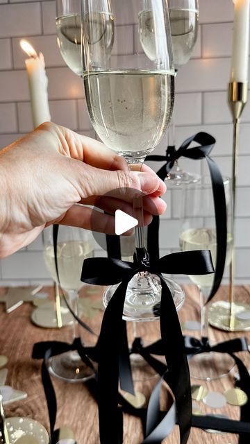 •Stephanie Bryant• on Instagram: "the bow trend?! I’m obsessed! 😍 the perfect finishing touch to a New Year’s Eve (or anytime)  party 🎀🥂🥂 here is how I make mine   Tie a knot onto your glass then form two bunny ears - cross the right one over the left then loop behind and thread it back through the center - pull both ears to tighten then pull on the ends until you’ve reached your desired size and shape bow!   Make sure to save this reel and  follow @the_blonde_kitchen for more entertaining tips! 🖤🤍  #theblondekitchen #tbksocialclub #supperclub #newyearseve #bowtrend #bow #partyideas #entertainingathome #tablesetting #tablescapes #entertainingideas #newyears #champagne #fayettevillear #holidayinspo #decorideas #partyinspo" New Years Eve Bachelorette Party, Bow Champagne Glasses, Bows On Glasses, Tying The Knot Engagement Party, Bows On Champagne Glasses, Champagne Glasses With Bows, Pearls And Bows Party, New Years Eve For Two, New Year’s Eve Engagement Party