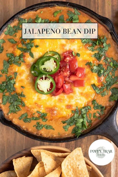 A cast iron skillet filled with bubbly cheese topped jalapeno bean dip sitting on top of a wooden cutting board. Jalapenos and chopped tomatoes garnish the dip. Jalapeno Bean Dip, Pinto Bean Dip, Mexican Bean Dip, Condiments Recipes, Mexican Flavors, Creamy Jalapeno, Pinto Bean, Condiment Recipes, Bean Dip