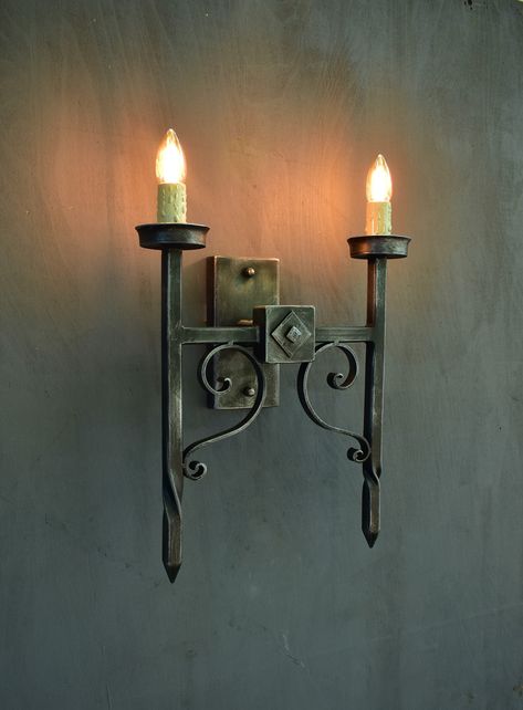 Gothic 2-light wall sconce,Medieval style torch shaped wall light,Wrought iron wallchiere Inspired by a Gothic castle, this fixture is made from wrought iron with a matte black iron finish with the possibility of patination with silver or copper patina. Wrought Iron Wall Lights, Cellar Basement, Blacksmith Workshop, Tuscan Interior, Welding Ideas, Torch Lamp, Gothic Castle, Rustic Hardware, The Torch