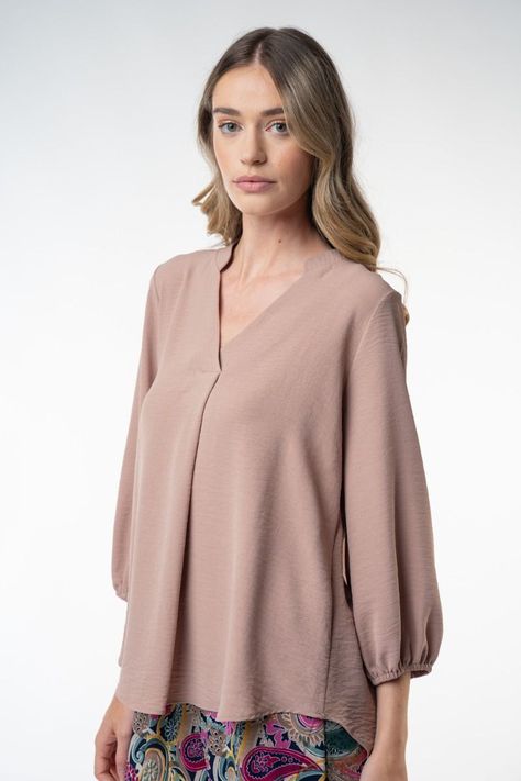 A three-quarter sleeve solid knit top with a notched neckline featuring elasticized sleeves and a loose fit. Fabric is a lightweight knit.Model is 5'10", has a long torso, and is wearing a size Small. FABRIC CONTENT 100% POLYESTER