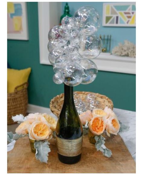 Bubbly centerpiece: Champagne bottle, Glass or plastic clear ornaments, wire coat hanger straightened out, string ornaments through wire hanger. Brunch Centerpieces, Champagne Bottle Sparklers, Champagne Centerpiece, Bottle Sparklers, Champagne Balloons, Brunch Decor, New Year's Party, Champagne Brunch, Bottle Centerpieces