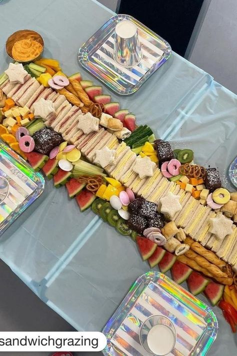 grazing table idea for kids party with fruits, sandwiches, pretzels, cheese, brownies, hummus... Party Graze Table, Kids Party Charcuterie Board, Kids Graze Table, Birthday Party Grazing Table, Toddler Birthday Party Food Ideas, Kids Party Table Set Up Ideas, Kids Party Food Table, Kids Grazing Table, Kids Party Sandwiches