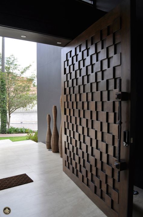 When it comes to tailor-made luxury front doors, treated wood is a much opted choice. They add to the sophistication of your space and can be customized for any design as well as finish. Cubes are an integral part of modern homes and this door confirms it. The brown cubes, in low alternating relief, show unique completeness.  Follow the the link bellow to learn more about this pivot wood door. Wooden Bifold Doors, Wooden Door Entrance, Doors Entry, House Main Door, Modern Entrance Door, Double Doors Exterior, House Main Door Design, Beautiful Front Doors, Wooden Main Door