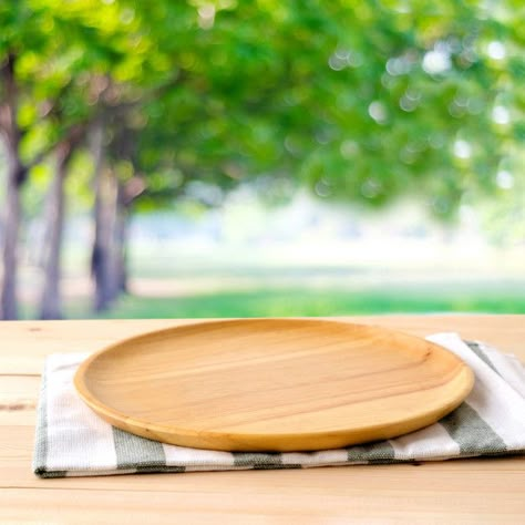 Empty round wooden tray and napery on table over blur tree background, for food and product display montage, template Premium Photo Background For Food Product, Table Product Display, Background For Food, Plate On Table, Food Background Wallpapers, Round Wooden Tray, Park Background, Food Photography Background, Background Food