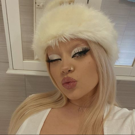 This is a photograph of a girl wearing glam makeup. She is wearing white and gray eyeshadow with a nude lipstick. White Eyebrows Makeup, White Bunny Makeup, Snow Bunny Makeup, Rave Eyeliner, White Makeup Ideas, White Makeup Looks, Winter Eyeshadow Looks, Eccentric Makeup, Y2k Eyeshadow