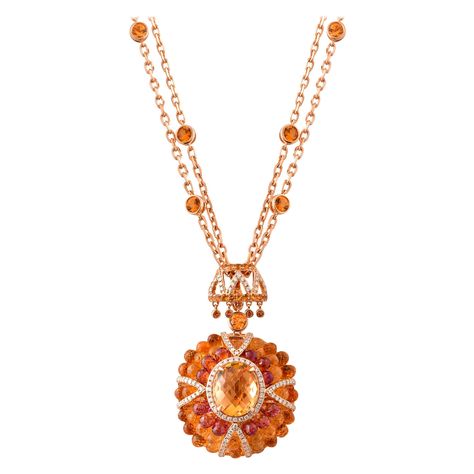 This is a chic citrine pendant necklace in a unique briollete cut to accentuate the colorful sparkle. The stunning center stone vibrantly sits on top of a cluster of beautiful citrine and rhodolite garnet drops. The unique architecture to construct and combine these gemstones makes this ring a true showstopper. The pendant can be detached from the two layered chain with orange sapphire accents giving you versatility with this product. Designer 2-in-1 citrine briolette pendant necklace with citrine, rhodolite, and orange sapphire in 18K rose gold. Citrine: 4.00 carat, oval briolette. Citrine: 10.84 carat, drops. Rhodolite: 5.34 carat, drops. Citrine: 0.255 carat, round shape. Orange Sapphire: 2.28 carat, round shape. Diamond: 0.52 carat, G color VS clarity. Gold: 27.931, 18K rose gold. Pend Briolette Necklace, Sparkling Jewelry, Orange Jewelry, Necklace With Diamond, Sabyasachi Jewellery, Diamond Pendent, Orange Necklace, Citrine Jewelry, Layered Chain