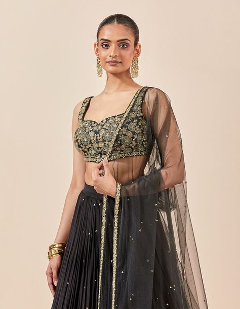 A lehenga set re-imagined for comfort and the celebration season vibes- this black lehenga brings you the charm of intricate hand embroidery that goes well with any occasion. As the first day of romance, this lehenga set is in full bloom with the voluminous lehenga skirt and beautifully done choli. This 3-piece set showcases a minimalistic charm attracting the purveyors of the "less is more" aesthetic.. Product Details. Color: Black. Work: Hand Embroidery. Style: Lehenga Set. Skirt Fabric: Crepe. Blouse Fabric: Chanderi Silk. Dupatta Fabric: Net