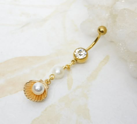 Seashell Pearl Dangle Belly Ring Show off your beautiful belly! Belly ring features a beautiful golden shell charm with faux pearl inside charm accented with a white freshwater pearl.  Belly button ring measures 2 1/4 inches long total length. Barbell is 14g gold-plated surgical steel with a 7/16" (11mm) wearable bar length. For Belly Button Rings: https://www.etsy.com/shop/AllAboutClass?section_id=18474235&ref=shopsection_leftnav_1  All body jewelry sales are final!!  AllAboutClass DOES NOT acc Bellybutton Piercings, Belly Button Piercing Jewelry, Dangle Belly Rings, Jewelry Tattoo, Belly Piercing, Belly Button Ring, Belly Button Piercing, Dope Jewelry, Button Ring