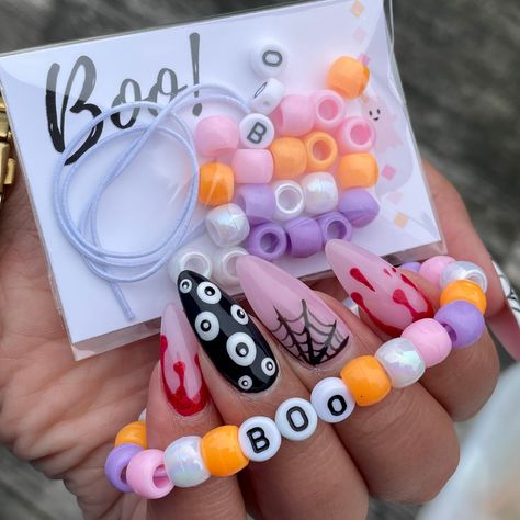 Looking for a fun interactive way to celebrate Halloween this year? Look no further! Personalized Individually Wrapped DIY Halloween Bracelet Kit is a great classroom or Girl Scout troop gift! Perfect for a Pink - A - Boo party! Each kit comes with: 12 inches of white elastic for bracelet  24 beads (6 white - 6 pink - 6 purple - 6 orange) BOO letter beads (1 B - 2 O's) Beads & elastic is placed in a clear tube !  WARNING: CHOKING HAZARD - Small parts. Not suitable for children under 3 years. Kids Halloween Class Gifts, Bracelet Kit Party Favor, Halloween Crafts For Party, Pink Orange Halloween Party, School Halloween Gifts, Small Halloween Party Ideas For Kids, Things To Sell For Halloween, Pink Halloween Bracelet, Halloween Gifts For Preschoolers