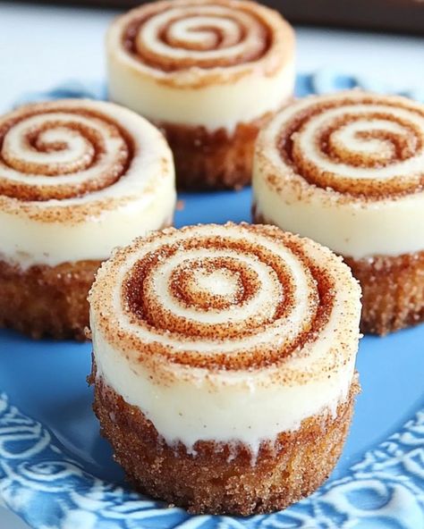 🍰 Mini Cinnamon Roll Cheesecakes 🍰 Ingredients: Crust: 1 cup vanilla wafer cookie crumbs 2 tablespoons sugar 1/2 teaspoon ground cinnamon 4 tablespoons melted butter Cheesecake Filling: 12 ounces cream cheese, softened 1/2 cup sugar 3 tablespoons flour 1/2 teaspoon ground cinnamon 1/2 cup sour cream 1 teaspoon vanilla extract 2 eggs Cinnamon Sugar Filling: 1 1/2 tablespoons ground cinnamon 1/4 cup sugar Frosting: 3 tablespoons butter 1/2 cup powdered sugar 1/4 teaspoon vanilla extract 1/... Mini Cinammon Rolls, Mini Cinnamon Roll Cheesecake, Wafer Cookie, Cinnamon Roll Cheesecake, Churro Cheesecake, Vanilla Wafer, Homemade Cookbook, Sugar Frosting, Cheesecake Filling